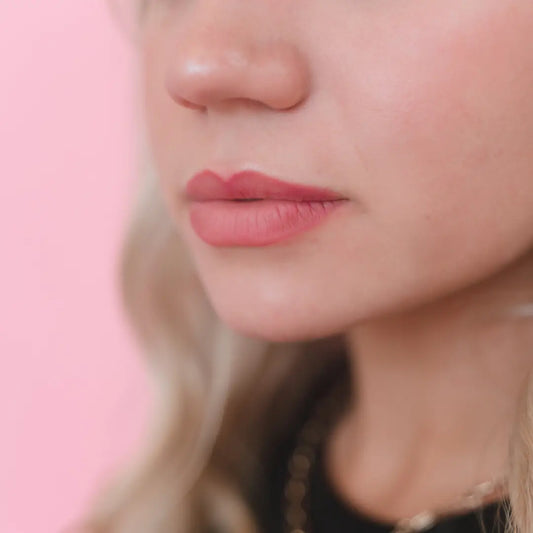 Close-up of a person's lips with a pink background