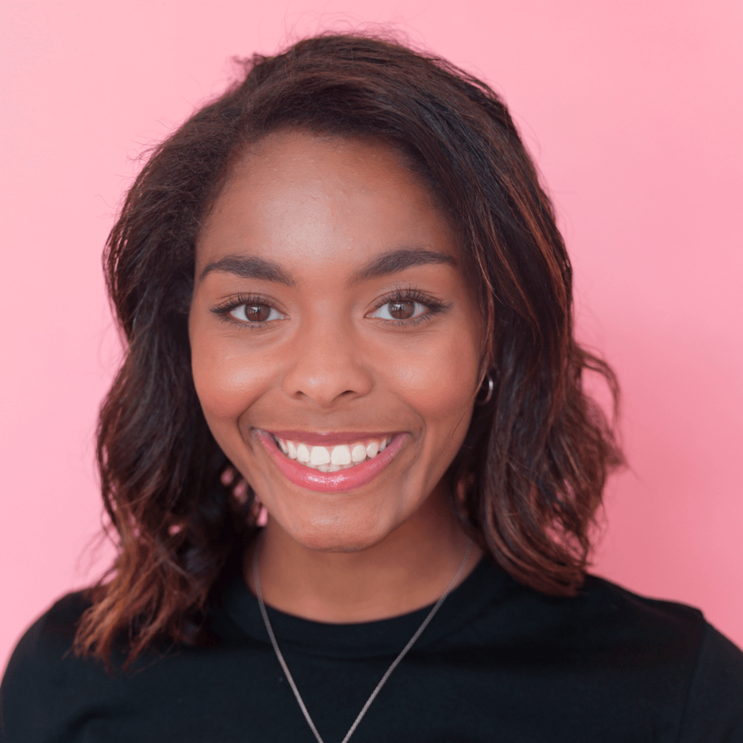 dark skin model wearing lip oil smiling