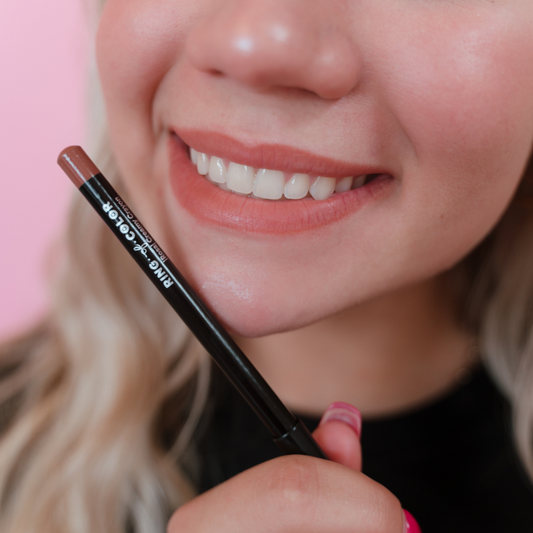 light skin model holding lip liner close to lips