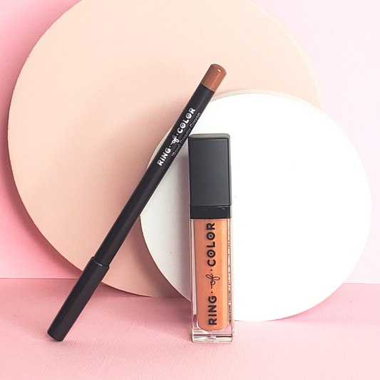 peach lip gloss and nude liner standing against each other with two circle props behind them