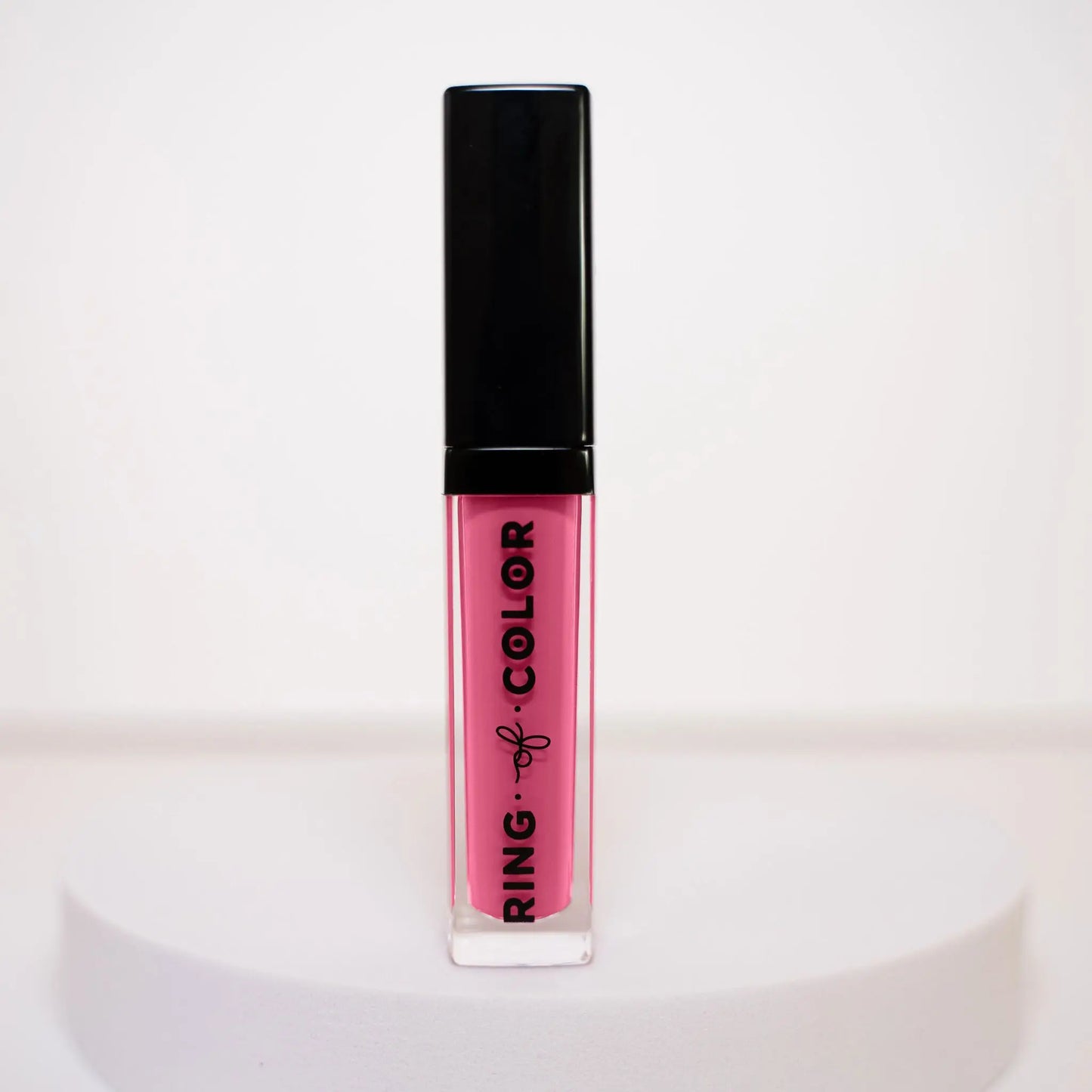 Pink lipstick with black cap on a white background