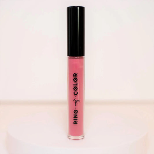 Pink lip gloss with black cap on a light pink background