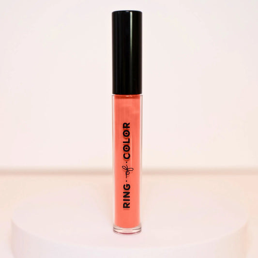 creamy mid tone marsala Lip gloss with black cap and 'Ring of Color' branding on a light background