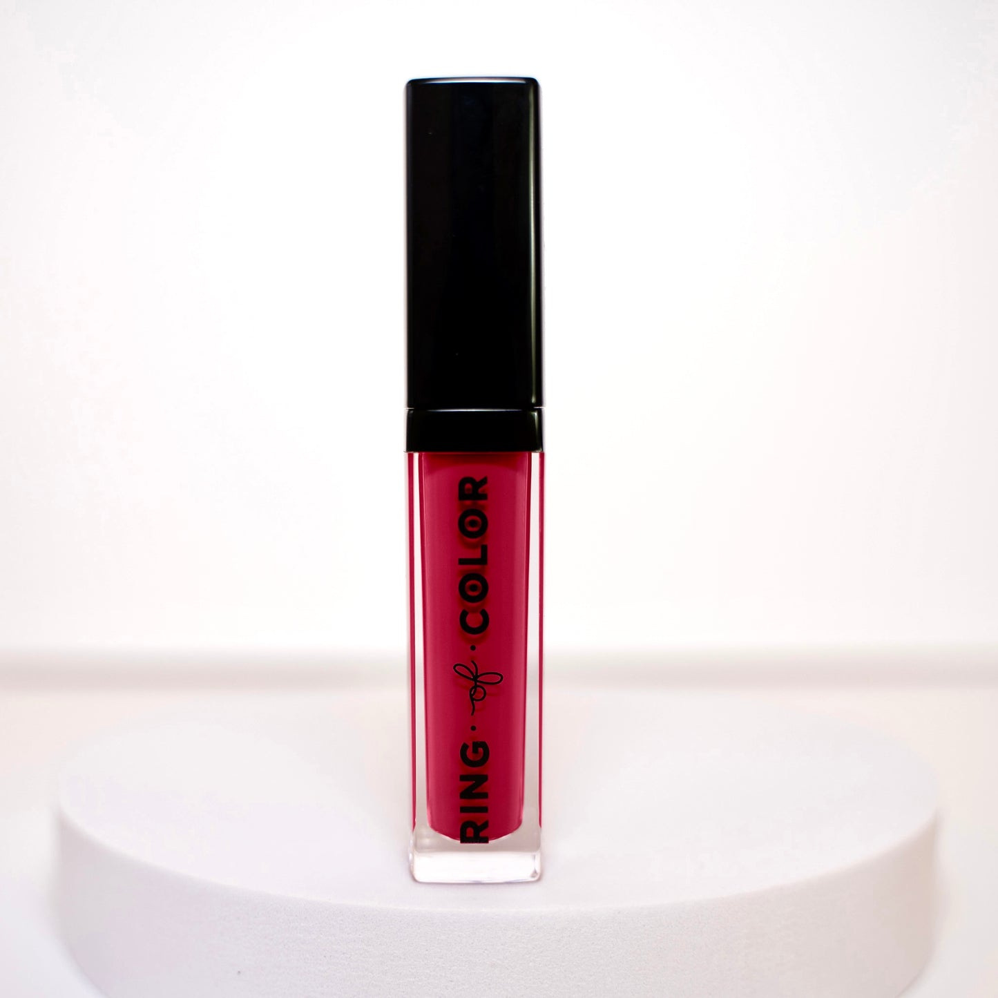 Lipstick with black cap and red liquid on a white background