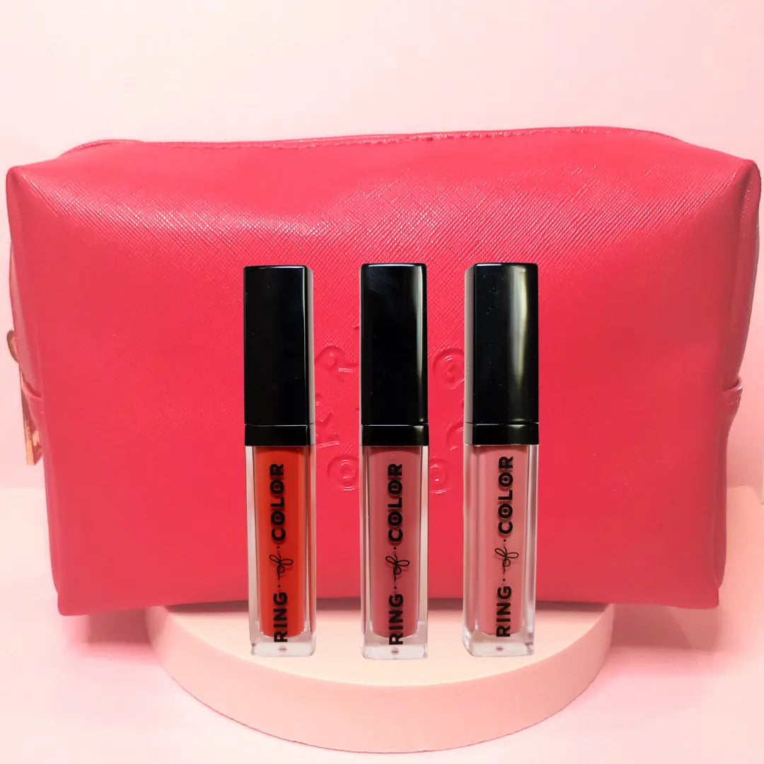 Three lipsticks with a pink pouch on a pink background