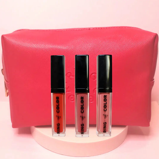 Three lipsticks with a pink pouch on a pink background