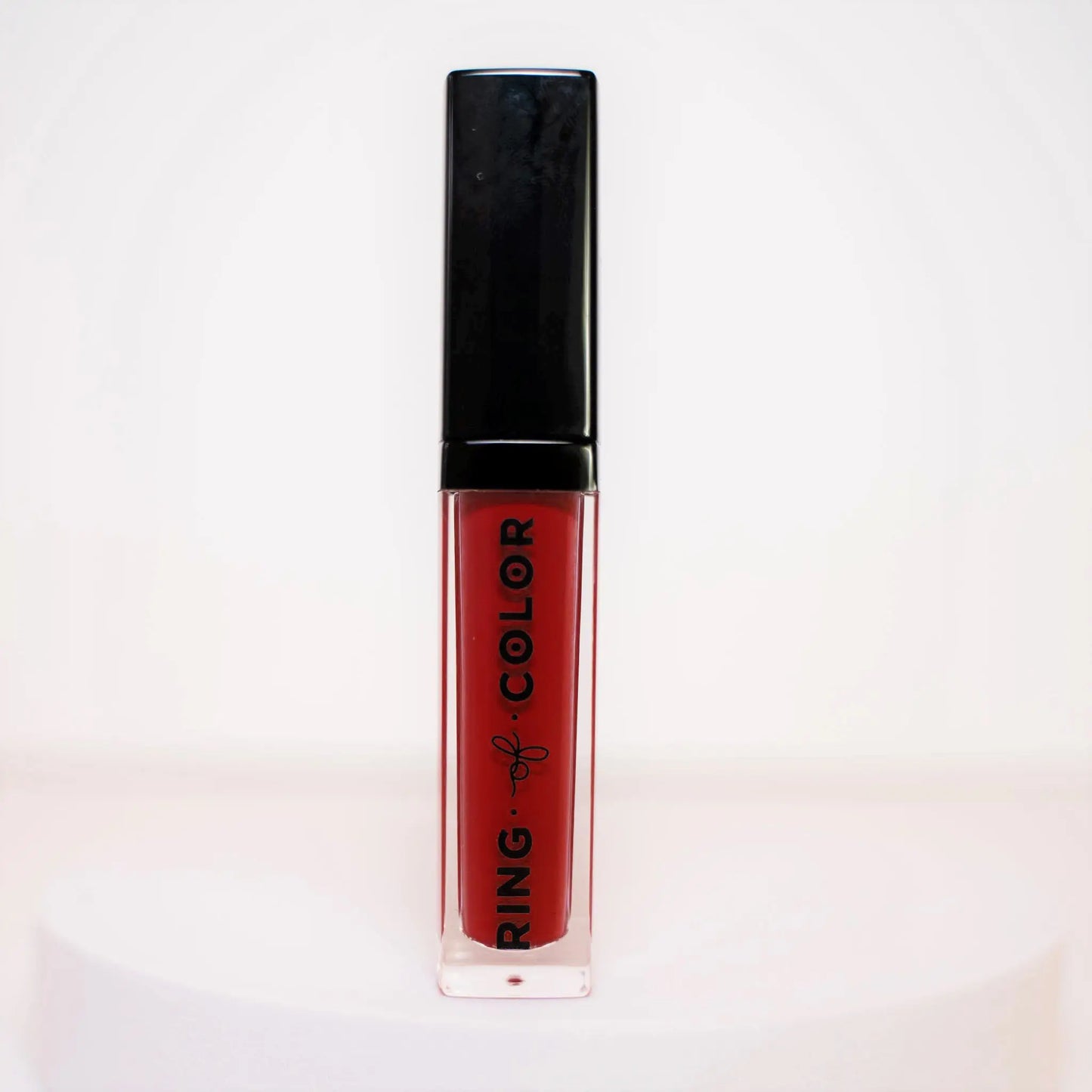 Red lipstick with black cap on a white background